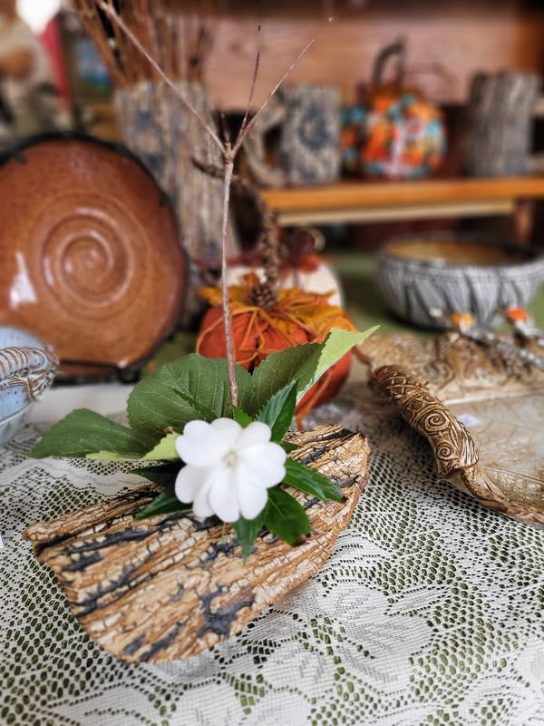 Textured handmade ikebana vase with a small flower at Tunnel Mountain Crafts