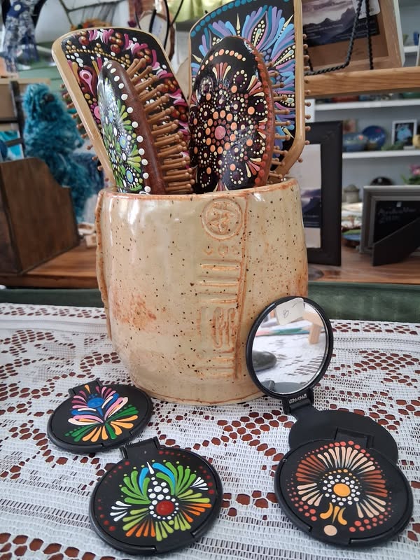 Colorfully hand-painted brushes and mirrors displayed at Tunnel Mountain Crafts